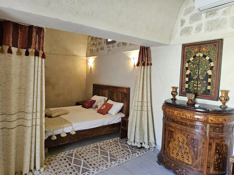 Chambre supérieure de Dar Zmen : lit double, rideaux tissés et commode ancienne