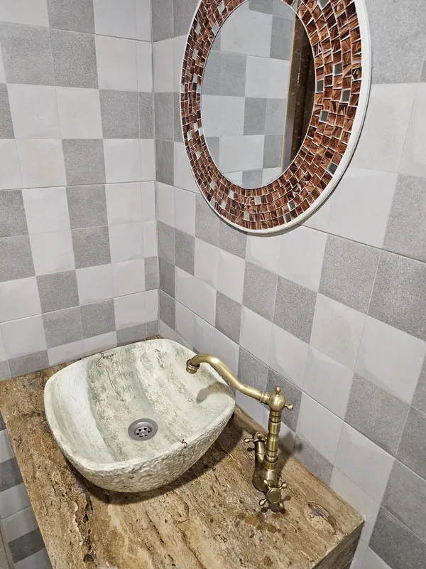 Salle de bain : vasque en pierre et miroir en mosaïque